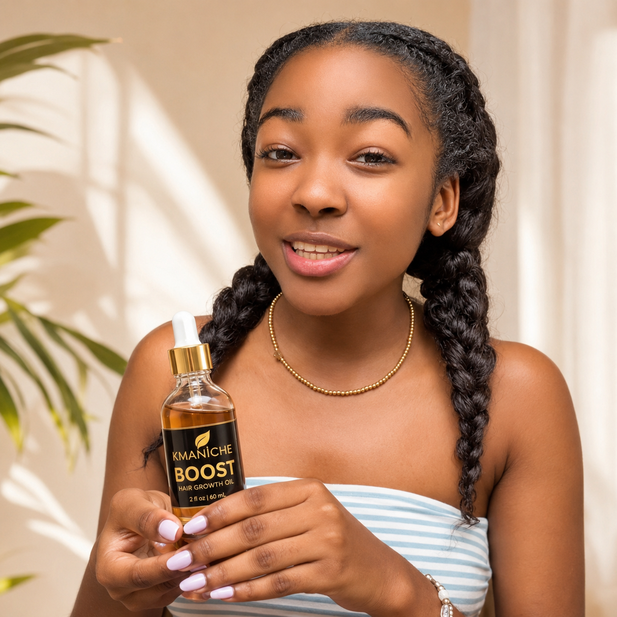 Ariana holding a bottle of Kmaniche Boost hair growth oil with a plant in the background